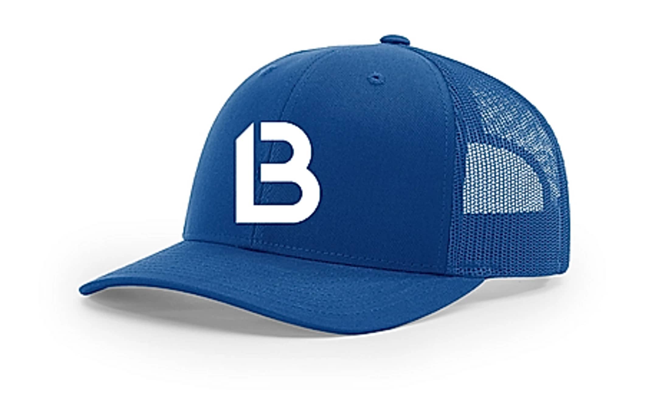 A royal blue baseball-style trucker hat with a mesh back, featuring a bold, white, stylized letter 'B' logo on the front, set on a white background.